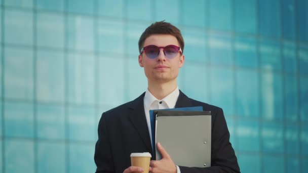 一位成功的年轻男性工程师或建筑师的肖像 持有站在蓝色窗户大楼附近的文件 — 图库视频影像
