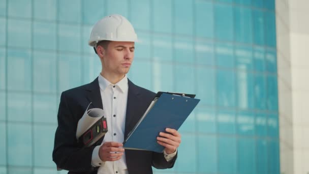 Чоловік Інженер Або Архітектор Шоломі Дивлячись Будівельні Малюнки Його Руці — стокове відео