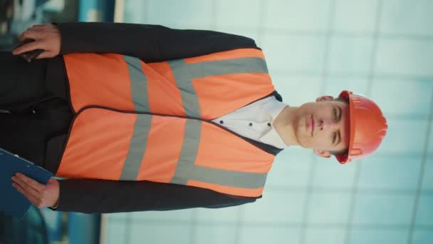 Portret Młodego Inżyniera Lub Architekta Noszącego Kask Kurtkę Bezpieczeństwa Trzymającego — Wideo stockowe