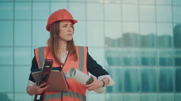 Молодая Женщина Инженер Архитектор Оранжевом Шлеме Пиджаке Безопасности Посмотрите Часы — стоковое видео