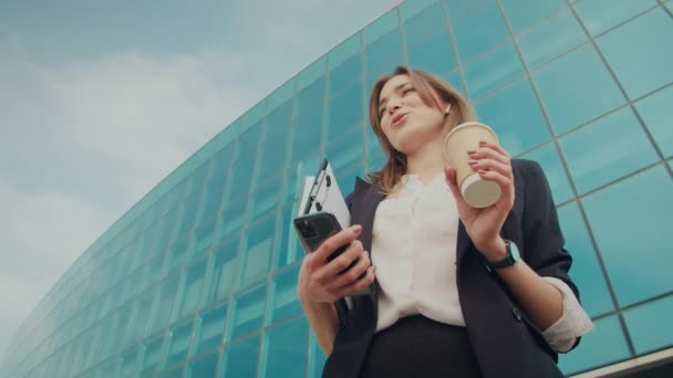 Cep Telefonuyla Konuşan Mutlu Kadını Yerinin Önünde Dikilirken Elinde Kulaklıkla — Stok video