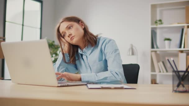 オフィスのコンピュータで睡眠不足の若い女性が働いている 退屈な女性フリーランサーは仕事から排出されます ワークライフバランス 効果的な時間管理 ホームでのワークスペースの組織 — ストック動画