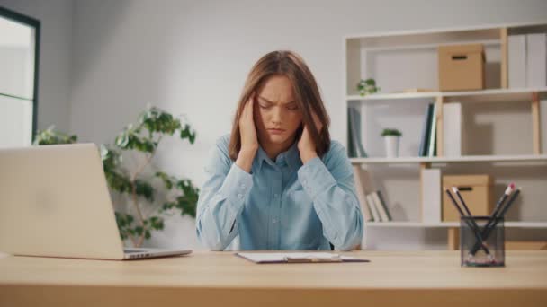 過労の女性労働者は コンピュータ過労のために痛みを伴う頭の感情を持っている 頭痛を持つ若い女性 自宅でコンピュータに取り組む若いビジネスマンストレスや仕事から病気を感じる — ストック動画