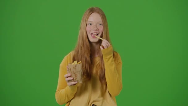 Tela Verde Menina Adolescente Loira Sorri Come Batatas Fritas Tendências — Vídeo de Stock