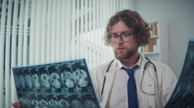 Bilgisayar ekranındaki röntgenleri ve CT taramalarını analiz eden bir doktor, Dijital Tıbbi Verileri doğru tanı ve tedavi planları sağlamak için gözden geçirir. Tıbbi Profesyonellik ve Uzman Bakımı kavramı