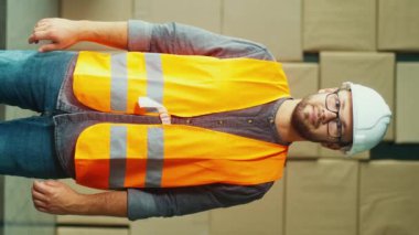 Dikey video. Hard Hat and Safety Yelek Mühendisi Yoğun İnşaat Alanında Çalışıyor, Dinamik bir Çevrede Esneklik ve Adaptasyon Gösteriyor.