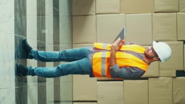 Dikey video. Hard Hat and Safety Yelek Mühendisi Yoğun İnşaat Alanında Çalışıyor, Dinamik bir Çevrede Esneklik ve Adaptasyon Gösteriyor.