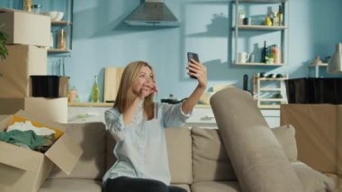 Gülümseyen bir çift yeni dairelerine taşınmayı Keys 'le selfie çekmeyi kutluyor. Kutularla çevrelenmiş bir şekilde birlikte yeni bir hayata başlamanın neşeli anını yakalıyorlar..