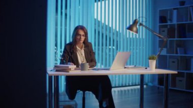 Genç Bir Kadın Ofis İşçisi Akşam Ofisinde Oturuyor, Geç Saatlere Kadar Çalışıyor ve Profesyonel Yorgunlukla Mücadele Ediyor Ve Ofis Yorgunluğu İyileşme Gereğini ve Uzun Saatlerin Gerilimini Vurguluyor