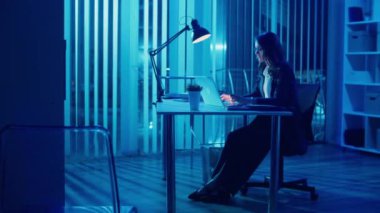 Genç Bir Kadın Ofis İşçisi Akşam Ofisinde Oturuyor, Geç Saatlere Kadar Çalışıyor ve Profesyonel Yorgunlukla Mücadele Ediyor Ve Ofis Yorgunluğu İyileşme Gereğini ve Uzun Saatlerin Gerilimini Vurguluyor