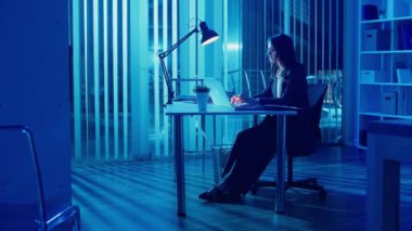 Genç Bir Kadın Ofis İşçisi Akşam Ofisinde Oturuyor, Geç Saatlere Kadar Çalışıyor ve Profesyonel Yorgunlukla Mücadele Ediyor Ve Ofis Yorgunluğu İyileşme Gereğini ve Uzun Saatlerin Gerilimini Vurguluyor