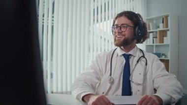 Uzaktan kumandalı tıbbi yardım sunan bir doktor video danışmanlığı vasıtasıyla hastalara yardım ediyor. Teletıp ve Çevrimiçi Sağlık Hizmetleri kavramı, Dijital Tıbbi Hizmetlerin Yararlarının Vurgulanması