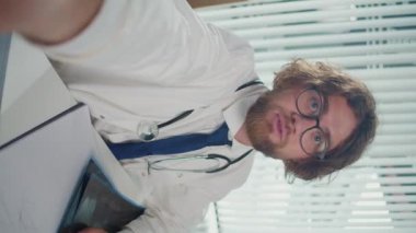 Dikey video. Bir Doktor, Hastalara Danışmak Uzaktan Tıbbi Yardım Vermek İçin Online Platformlar Kullanıyor. Teletıp kavramı, uygun ve ulaşılabilir sağlık hizmeti sağlama.