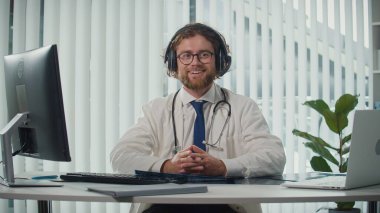 Uzaktan kumandalı tıbbi yardım sunan bir doktor video danışmanlığı vasıtasıyla hastalara yardım ediyor. Teletıp ve Çevrimiçi Sağlık Hizmetleri kavramı, Dijital Tıbbi Hizmetlerin Yararlarının Vurgulanması