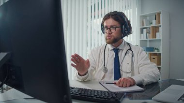 Uzaktan kumandalı tıbbi yardım sunan bir doktor video danışmanlığı vasıtasıyla hastalara yardım ediyor. Teletıp ve Çevrimiçi Sağlık Hizmetleri kavramı, Dijital Tıbbi Hizmetlerin Yararlarının Vurgulanması