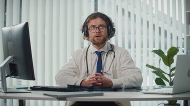 Uzaktan kumandalı tıbbi yardım sunan bir doktor video danışmanlığı vasıtasıyla hastalara yardım ediyor. Teletıp ve Çevrimiçi Sağlık Hizmetleri kavramı, Dijital Tıbbi Hizmetlerin Yararlarının Vurgulanması