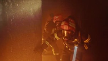 İtfaiyeciler Hayat Tehdidi Koşullarında Cesaret ve Kahramanlık Göstererek Duman Dolu, Yanan Koridorda Dikkatlice İlerler. Başkalarını kurtarmak için hayatlarını tehlikeye atıyorlar, gerçek cesareti vurguluyorlar.