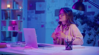 Dijital özgüven, uzaktan çalışma, neon ruh hali. Kadın şık bir İçişleri Bakanlığı 'nda oturuyor ve bir iş videosunda konuşuyor. Kalın Yaratıcı Alan 'da Odaklanma ve Otoriteyi Temizle