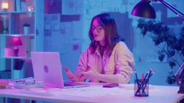 Dijital özgüven, uzaktan çalışma, neon ruh hali. Kadın şık bir İçişleri Bakanlığı 'nda oturuyor ve bir iş videosunda konuşuyor. Kalın Yaratıcı Alan 'da Odaklanma ve Otoriteyi Temizle