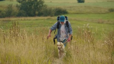 Terapi Yürüyüşü, Doğal Rehabilitasyon. Sırt çantalı yaşlı adam köpeğiyle dağları aşıyor. Emeklilikten sonra Sakin, Hareketlilik İyileştirme ve Açık Hava Sağlığı Seyahati