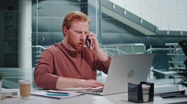 Yanık Duygusal Yük, Ofis Stres, Zihinsel Yorgunluk. Çağdaş bir ofiste, aşırı yük ve gerilimle mücadele eden yıpranmış bir adam masasında çalışıyor. Gerçekçi Baskı ve Duygusal Yorgunluk Sahnesi