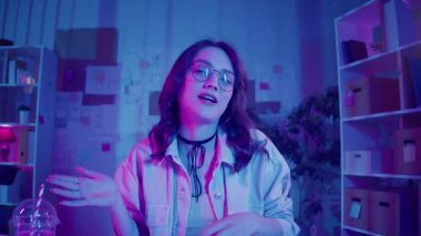 Sosyal medya, içerik yaratma, görsel kimlik. Kadın Neon Home Studio 'da oturuyor ve Vlog' unu kaydediyor. Genel Z Çevrimiçi İletişim için Parlak Kişisel Alan ve Dijital Varlık