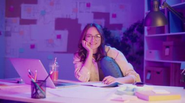 Güçlendirilmiş Öğrenme, Akademik Özgüven, Dijital Çağ. Öğrenci rahat poz verip Neon Room 'daki kameraya bakar. Odaklanma, Odaklanma ve Eğitimin Yeni Yüzü