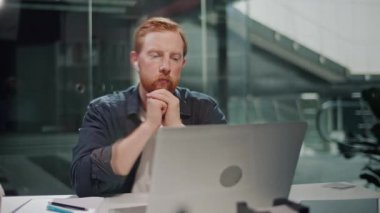 Yanık Duygusal Yük, Ofis Stres, Zihinsel Yorgunluk. Çağdaş bir ofiste, aşırı yük ve gerilimle mücadele eden yıpranmış bir adam masasında çalışıyor. Gerçekçi Baskı ve Duygusal Yorgunluk Sahnesi