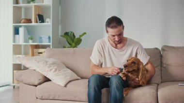 Sağlıklı Hayvan Yiyecekleri, Duygusal Denge, Yaşam Tarzı Kaynaşması. Genç Adam Kanepede Kızarmış Patates Yiyor, Yanında Sağlıklı Muameleden Hoşlanan Köpek Var. Rahatlamış Bakım, Bağlantı ve Paylaşılan Zihinsel Sağlık Anı