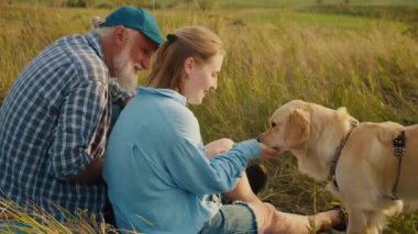Hayvan-Kapsayıcı Aile Zamanı. Son sınıf öğrencisi ailesi ve köpeği ile birlikte çadırda oturur ve güzel manzaraya hayran kalır. Beraberliğin Huzurlu Anı, Doğa ve Sevilen Evcil Hayvanla Neşeli Yaşam