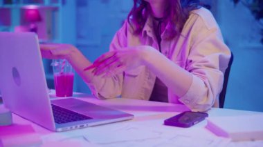 Sanal Liderlik, Uzaktan Çalışma, Neon Estetik. Yaratıcı Neon Ofisindeki Kadın Bir İş Videosu Görüşmesi Yönetti. Gayri resmi ama Profesyonel Çevrede Güvenilir Dijital Varlık