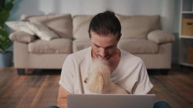 Duygusal Destek, Akıl Sağlığı, İş-Yaşam Dengesi. Evden Genç Adam Çalışıyor, Köpeği Yanında Otururken Çevrimiçi Toplantıya Odaklanıyor. Dijital Bağlantının Sakin Anı ve Hayvan güdümlü İstikrar