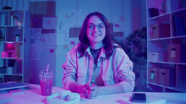 Sosyal medya, içerik yaratma, görsel kimlik. Kadın Neon Home Studio 'da oturuyor ve Vlog' unu kaydediyor. Genel Z Çevrimiçi İletişim için Parlak Kişisel Alan ve Dijital Varlık