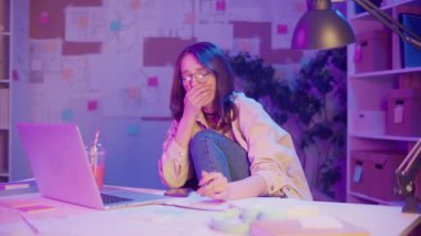 Zihinsel Yük, Duygusal Yanma, Dijital Rutin. Yorgun Kadın Neon Room 'da Gece Geç Saatlere Kadar Çalışmaya Devam Ediyor. Modern Yaratıcı Yaşamda Aşırı Yükleme ve Hırsa Gerçekçi Bir Bakış