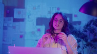 Sanal Liderlik, Uzaktan Çalışma, Neon Estetik. Yaratıcı Neon Ofisindeki Kadın Bir İş Videosu Görüşmesi Yönetti. Gayri resmi ama Profesyonel Çevrede Güvenilir Dijital Varlık