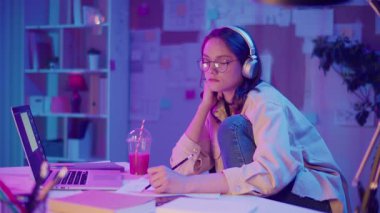 Yaratıcı Endüstriler, Geleceğin Meslekleri, Dijital Gençlik. Neon Room 'daki Genç Kız ödev ya da Yaratıcı Proje üzerine çalışıyor. Kişisel Alandaki Tasarım, İçerik veya Kodlamadan Odaklanmış ve İlham Almış