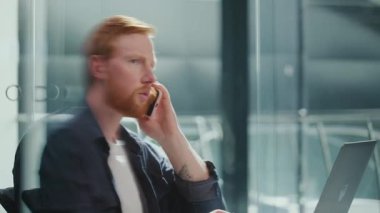 Ofis Minimalist Yaşam Tarzı, Dikkatli Çalışma, Estetik Odaklanma. Modern bir ofiste çalışan bir adam profesyonel bir telefon görüşmesi yapar. Sakin, Organize Odaklanma ve Basit Üretkenlik Sahnesi
