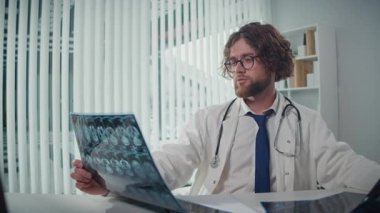 Bilgisayar ekranındaki röntgenleri ve CT taramalarını analiz eden bir doktor, Dijital Tıbbi Verileri doğru tanı ve tedavi planları sağlamak için gözden geçirir. Tıbbi Profesyonellik ve Uzman Bakımı kavramı