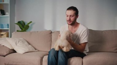Sağlıklı Hayvan Yiyecekleri, Duygusal Denge, Yaşam Tarzı Kaynaşması. Genç Adam Kanepede Kızarmış Patates Yiyor, Yanında Sağlıklı Muameleden Hoşlanan Köpek Var. Rahatlamış Bakım, Bağlantı ve Paylaşılan Zihinsel Sağlık Anı