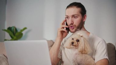 Duygusal Destek, Akıl Sağlığı, İş-Yaşam Dengesi. Evden Genç Adam Çalışıyor, Köpeği Yanında Otururken Çevrimiçi Toplantıya Odaklanıyor. Dijital Bağlantının Sakin Anı ve Hayvan güdümlü İstikrar