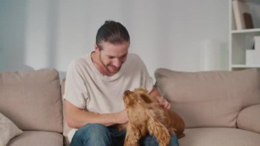 Yavaş Yaşam, Akıl Sağlığı, Hayvan Rahatlığı. Adam kanepeye uzanmış köpeğiyle dinleniyor. Basit, Duygusal Bağlanma, Varlık ve Evde Sakinlik Anı