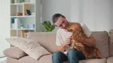 Sağlıklı Hayvan Yiyecekleri, Duygusal Denge, Yaşam Tarzı Kaynaşması. Genç Adam Kanepede Kızarmış Patates Yiyor, Yanında Sağlıklı Muameleden Hoşlanan Köpek Var. Rahatlamış Bakım, Bağlantı ve Paylaşılan Zihinsel Sağlık Anı