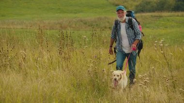 Terapi Yürüyüşü, Doğal Rehabilitasyon. Sırt çantalı yaşlı adam köpeğiyle dağları aşıyor. Emeklilikten sonra Sakin, Hareketlilik İyileştirme ve Açık Hava Sağlığı Seyahati