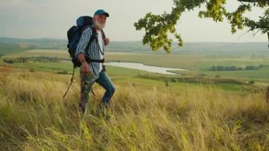 Amaçlı Yolculuk, Geç Yaşam Keşfi. Yaşlı adam panoramik dağ manzarasında yürüyor, Ağaçlar, Çimenler ve Gökyüzü ile çevrili. Sonraki yıllarda Doğa ve Kişisel Büyümeyi Kucaklayan Ruhsal Macera