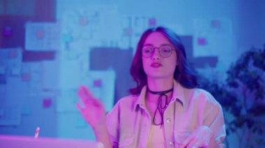 İş-Hayat Dengesi, Dijital Yaşam Tarzı, Neon Mood. Yaratıcı İçişleri Bakanlığı 'ndaki genç kadın iş videolarına katıldı. Modern Esnek Çalışma Ortamı İçin Sakin Odaklanma ve Rahatlık