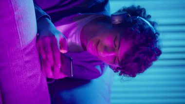 Man, Kanepe Kaydırma Telefonunda Rahatlıyor, Muhtemelen Podcast veya Browsing dinliyor. Günlük Kişisel Bakım ve Dijital Çağ 'da Yavaş Yaşam. Dikey Video, Dijital Detox, Ruh Sağlığı, Odaklanma Kipi.