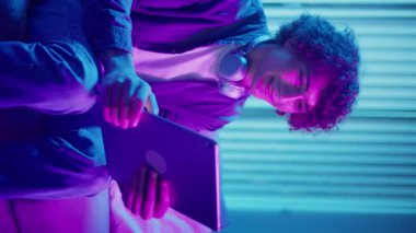 Man, Tablet Kullanarak Koltuğa Rahatlar, Muhtemelen Okuma ve Yayınlama İçeriğini İzler. Günlük Kişisel Bakım ve Dijital Çağ 'da Yavaş Yaşam. Dikey Video, Dijital Detox, Ruh Sağlığı, Odaklanma Kipi.