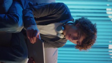 Man, Tablet Kullanarak Koltuğa Rahatlar, Muhtemelen Okuma ve Yayınlama İçeriğini İzler. Günlük Kişisel Bakım ve Dijital Çağ 'da Yavaş Yaşam. Dikey Video, Dijital Detox, Ruh Sağlığı, Odaklanma Kipi.