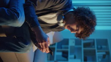 Man, Kanepe Kaydırma Telefonunda Rahatlıyor, Muhtemelen Podcast veya Browsing dinliyor. Günlük Kişisel Bakım ve Dijital Çağ 'da Yavaş Yaşam. Dikey Video, Dijital Detox, Ruh Sağlığı, Odaklanma Kipi.