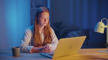 Akşam Masada Oturan Genç Kadın Dizüstü bilgisayar ekranında okuyor. Okuduktan sonra, sessizce ellerini katlayarak dua eder, tanrıların varlığını arar. Huzurlu Ruhani Anlık, İnanç ve İç Yansıma.